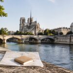 Paris map and travel notebook beside the Seine near Notre-Dame
